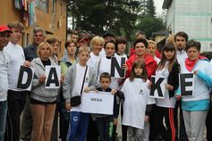 Betroffene Frauen, Kinder und Männer halten ein DANKE-Schild in die Kamera - Hochwasser Bosnien 2014